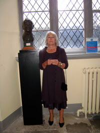 Liadain O’Donovan standing beside the UCC bronze head sculpture of her father by artist Seamus Murphy.
